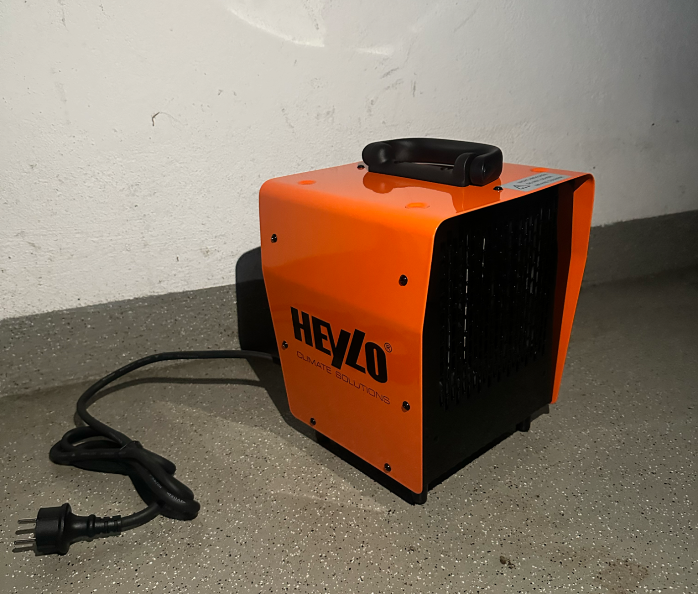 Oranger Heizlüfter mit Griff und Kabel